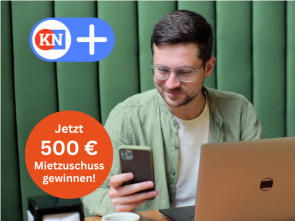 Student sitzt lächelnd vor einem Laptop und hat ein Handy in der Hand. Er konsumiert das Angebot von KN+. Infotext: Jetzt 500 € Mietzuschuss gewinnen!