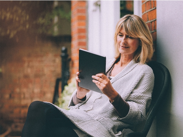 Frau liest das E-Paper auf einem Tablet.